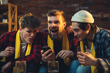 Image showing Group of friends watching TV, sport match together. Emotional fans cheering for favourite team, watching on exciting game. Concept of friendship, leisure activity, emotions