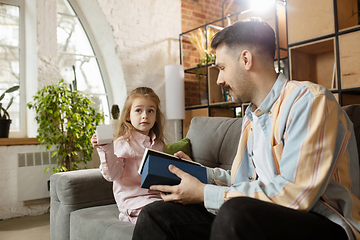 Image showing Happy father and little cute daughter at home. Family time, togehterness, parenting and happy childhood concept. Weekend with sincere emotions.