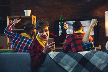 Image showing Group of friends watching TV, sport match together. Emotional man cheering for favourite team, celebrating successful betting. Concept of friendship, leisure activity, emotions