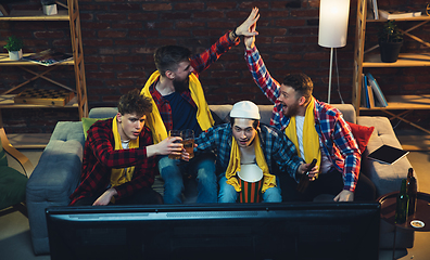 Image showing Group of friends watching TV, sport match together. Emotional fans cheering for favourite team, watching on exciting game. Concept of friendship, leisure activity, emotions