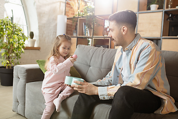 Image showing Happy father and little cute daughter at home. Family time, togehterness, parenting and happy childhood concept. Weekend with sincere emotions.