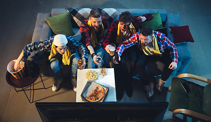 Image showing Group of friends watching TV, sport match together. Emotional fans cheering for favourite team. Top view. Concept of friendship, leisure activity, emotions
