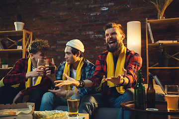 Image showing Group of friends watching TV, sport match together. Emotional fans cheering for favourite team, watching on exciting game. Concept of friendship, leisure activity, emotions