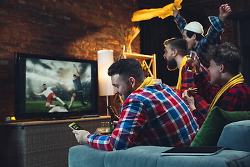 Image showing Group of friends watching TV, sport match together. Emotional fans cheering for favourite team, watching on exciting game. Concept of friendship, leisure activity, emotions