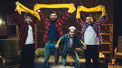 Image showing Group of friends watching TV, sport match together. Emotional fans cheering for favourite team, watching on exciting game. Concept of friendship, leisure activity, emotions