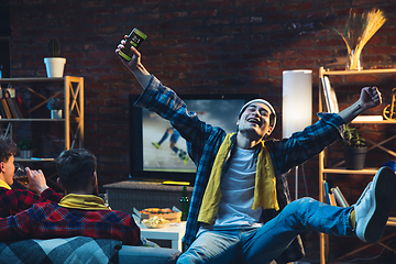 Image showing Group of friends watching TV, sport match together. Emotional fans cheering for favourite team, watching on exciting game. Concept of friendship, leisure activity, emotions