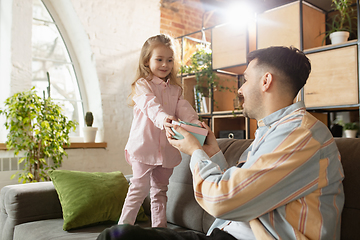 Image showing Happy father and little cute daughter at home. Family time, togehterness, parenting and happy childhood concept. Weekend with sincere emotions.