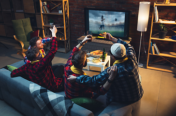 Image showing Group of friends watching TV, sport match together. Emotional fans cheering for favourite team, watching on exciting game. Concept of friendship, leisure activity, emotions