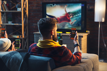 Image showing Group of friends watching TV, sport match together. Emotional fans cheering for favourite team, watching on exciting game. Concept of friendship, leisure activity, emotions