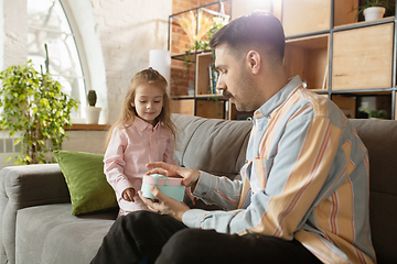 Image showing Happy father and little cute daughter at home. Family time, togehterness, parenting and happy childhood concept. Weekend with sincere emotions.