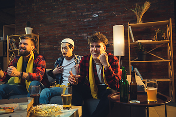 Image showing Group of friends watching TV, sport match together. Emotional fans cheering for favourite team, watching on exciting game. Concept of friendship, leisure activity, emotions