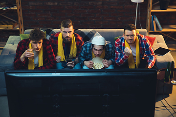 Image showing Group of friends watching TV, sport match together. Emotional fans cheering for favourite team, watching on exciting game. Concept of friendship, leisure activity, emotions