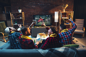 Image showing Group of friends watching TV, sport match together. Emotional fans cheering for favourite team, watching on exciting game. Concept of friendship, leisure activity, emotions