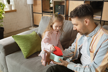 Image showing Happy father and little cute daughter at home. Family time, togehterness, parenting and happy childhood concept. Weekend with sincere emotions.