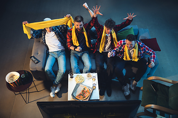 Image showing Group of friends watching TV, sport match together. Emotional fans cheering for favourite team. Top view. Concept of friendship, leisure activity, emotions