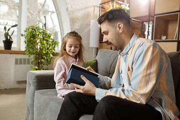 Image showing Happy father and little cute daughter at home. Family time, togehterness, parenting and happy childhood concept. Weekend with sincere emotions.