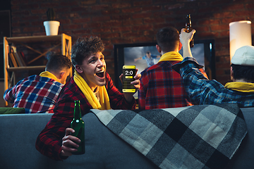 Image showing Group of friends watching TV, sport match together. Emotional man cheering for favourite team, celebrating successful betting. Concept of friendship, leisure activity, emotions