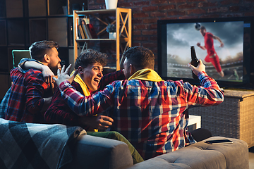 Image showing Group of friends watching TV, sport match together. Emotional fans cheering for favourite team, watching on exciting game. Concept of friendship, leisure activity, emotions