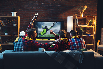 Image showing Group of friends watching TV, sport match together. Emotional fans cheering for favourite team, watching on exciting game. Concept of friendship, leisure activity, emotions