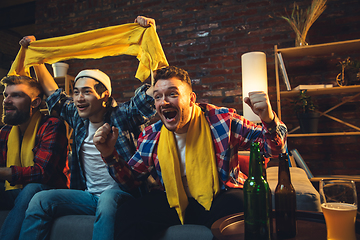 Image showing Group of friends watching TV, sport match together. Emotional fans cheering for favourite team, watching on exciting game. Concept of friendship, leisure activity, emotions