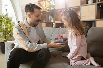 Image showing Happy father and little cute daughter at home. Family time, togehterness, parenting and happy childhood concept. Weekend with sincere emotions.