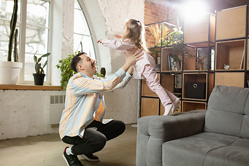 Image showing Happy father and little cute daughter at home. Family time, togehterness, parenting and happy childhood concept. Weekend with sincere emotions.