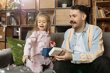 Image showing Happy father and little cute daughter at home. Family time, togehterness, parenting and happy childhood concept. Weekend with sincere emotions.