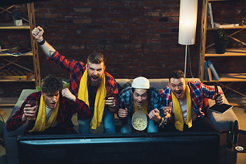 Image showing Group of friends watching TV, sport match together. Emotional fans cheering for favourite team, watching on exciting game. Concept of friendship, leisure activity, emotions