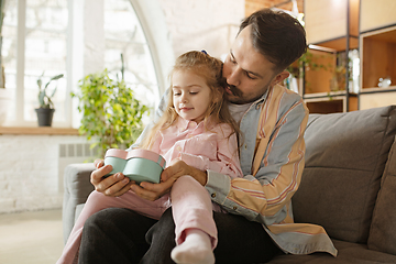 Image showing Happy father and little cute daughter at home. Family time, togehterness, parenting and happy childhood concept. Weekend with sincere emotions.