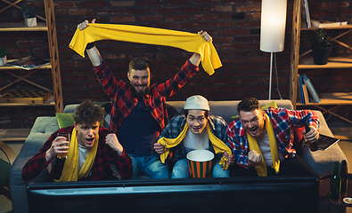 Image showing Group of friends watching TV, sport match together. Emotional fans cheering for favourite team, watching on exciting game. Concept of friendship, leisure activity, emotions