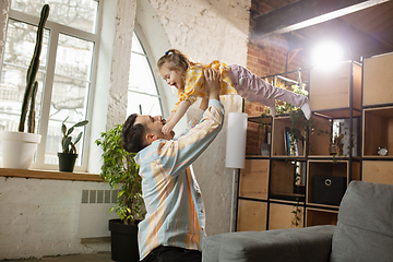 Image showing Happy father and little cute daughter at home. Family time, togehterness, parenting and happy childhood concept. Weekend with sincere emotions.