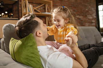 Image showing Happy father and little cute daughter at home. Family time, togehterness, parenting and happy childhood concept. Weekend with sincere emotions.