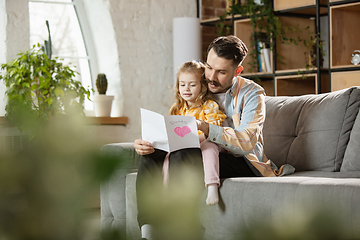 Image showing Happy father and little cute daughter at home. Family time, togehterness, parenting and happy childhood concept. Weekend with sincere emotions.