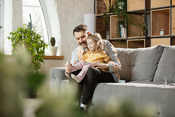 Image showing Happy father and little cute daughter at home. Family time, togehterness, parenting and happy childhood concept. Weekend with sincere emotions.