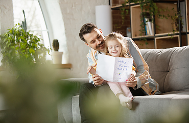 Image showing Happy father and little cute daughter at home. Family time, togehterness, parenting and happy childhood concept. Weekend with sincere emotions.