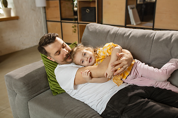 Image showing Happy father and little cute daughter at home. Family time, togehterness, parenting and happy childhood concept. Weekend with sincere emotions.