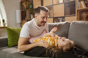 Image showing Happy father and little cute daughter at home. Family time, togehterness, parenting and happy childhood concept. Weekend with sincere emotions.