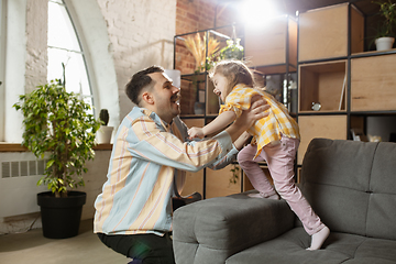 Image showing Happy father and little cute daughter at home. Family time, togehterness, parenting and happy childhood concept. Weekend with sincere emotions.