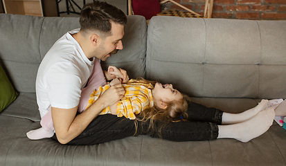 Image showing Happy father and little cute daughter at home. Family time, togehterness, parenting and happy childhood concept. Weekend with sincere emotions.