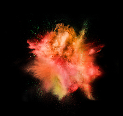 Image showing Explosion of colored, fluid and neoned powder on black studio background with copyspace