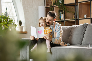 Image showing Happy father and little cute daughter at home. Family time, togehterness, parenting and happy childhood concept. Weekend with sincere emotions.