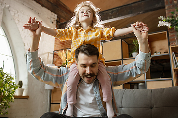 Image showing Happy father and little cute daughter at home. Family time, togehterness, parenting and happy childhood concept. Weekend with sincere emotions.