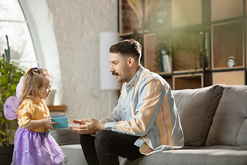 Image showing Happy father and little cute daughter at home. Family time, togehterness, parenting and happy childhood concept. Weekend with sincere emotions.