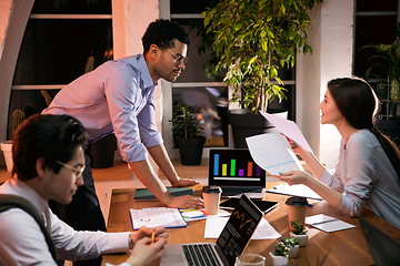 Image showing Colleagues working together in modern office using devices and gadgets during creative meeting