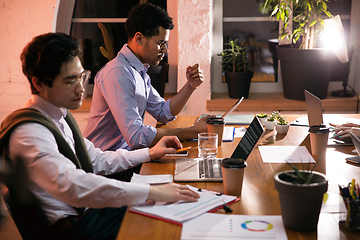 Image showing Colleagues working together in modern office using devices and gadgets during creative meeting