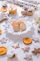 Image showing Christmas time, homemade cookies with ornaments and winter decorations in white