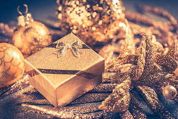 Image showing Christmas ornaments with small present in golden tones