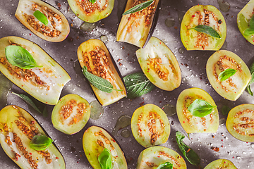 Image showing Small raw eggplants prepared for baking on baking sheet