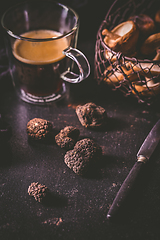 Image showing Black truffle on dark kitchen table with black coffee and mushrooms 