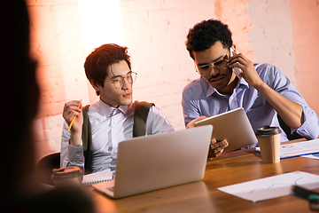 Image showing Colleagues working together in modern office using devices and gadgets during creative meeting